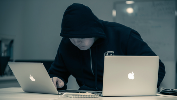 Hacker vor zwei Laptops